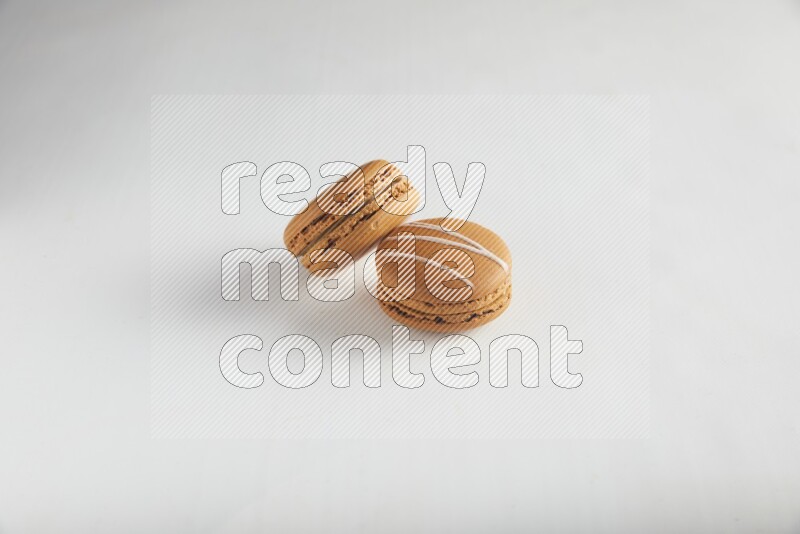 45º Shot of of two assorted Brown Irish Cream, and Brown Maple Taffy macarons  on white background