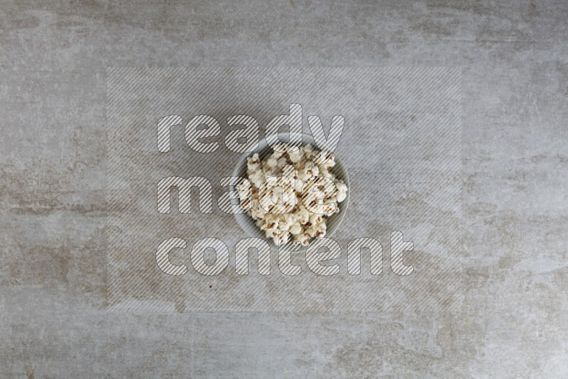 popcorn in gray bowl on a grey textured countertop