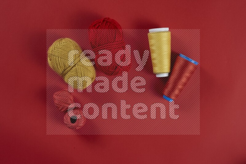 A yellow collection of sewing and tailoring tools arranged on a red background