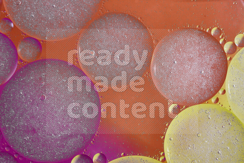 لقطات مقربة لفقاعات من الزيت على سطح الماء باللون الأصفر والبرتقالي والوردي