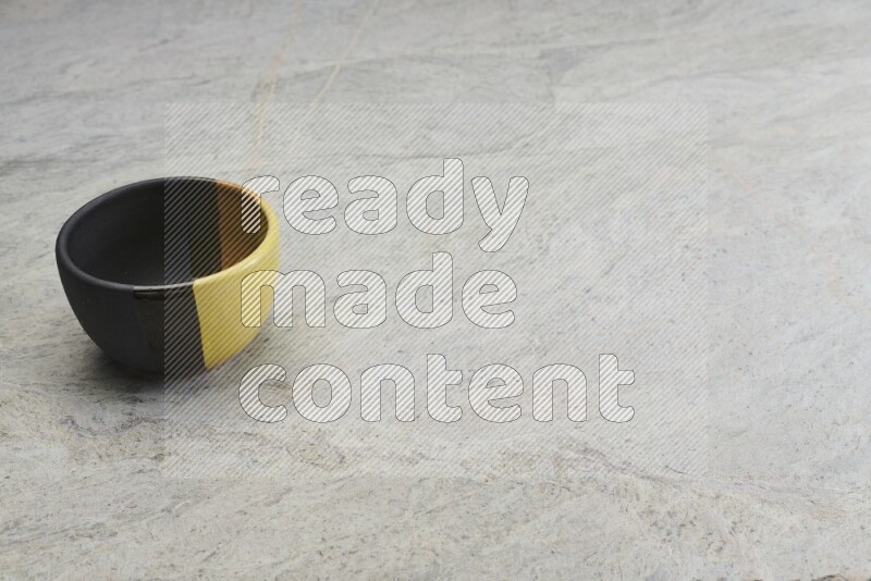 A multicolored pottery bowl on grey marble background