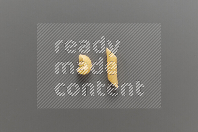 Pipe pasta with other types of pasta on grey background
