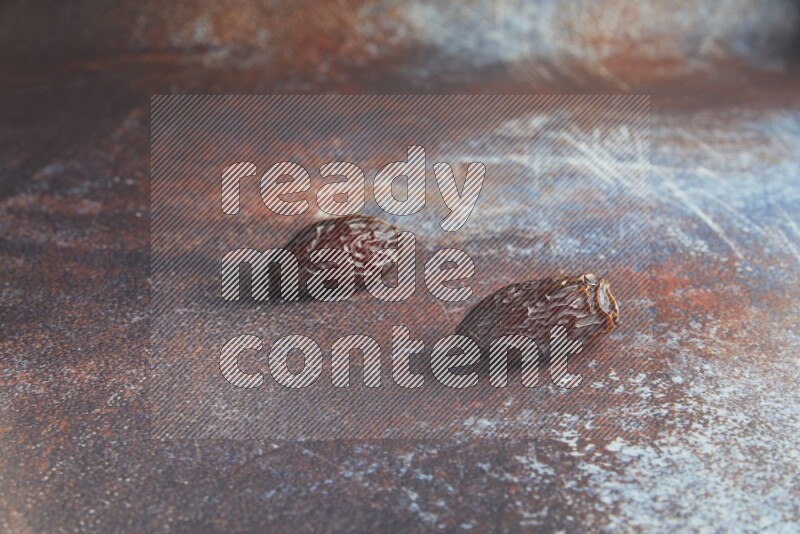 two madjoul dates on a rustic reddish background