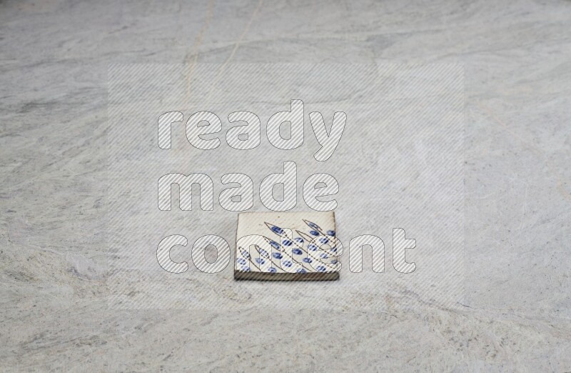 Top view shot of a pottery coaster\ tile on beige marble flooring