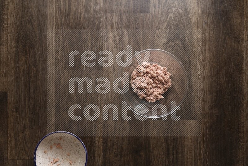 A glass bowl full of tuna, avocado, mango, blackberry and strawberry on wooden background