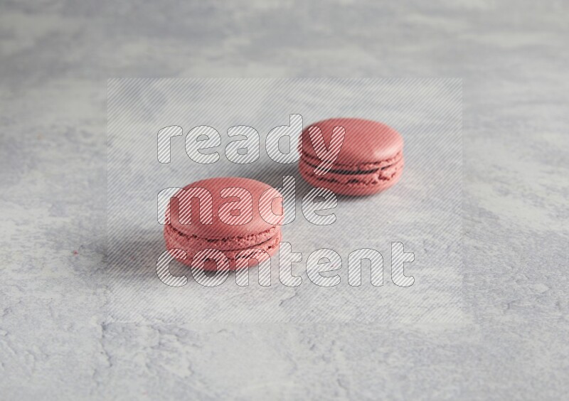 45º Shot of two Pink Raspberry macarons  on white  marble background