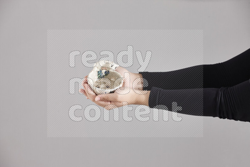 A woman in black abaya holding different pottery essentials in different positions