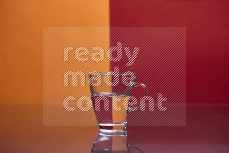 The image features a clear glassware filled with water, set against orange and red background