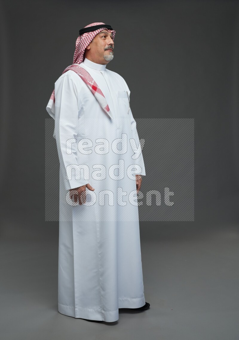 Saudi man with shomag Standing Interacting with the camera on gray background