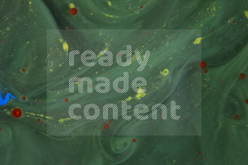 The image captures a dramatic splatter of yellow, red and blue paints over a green backdrop