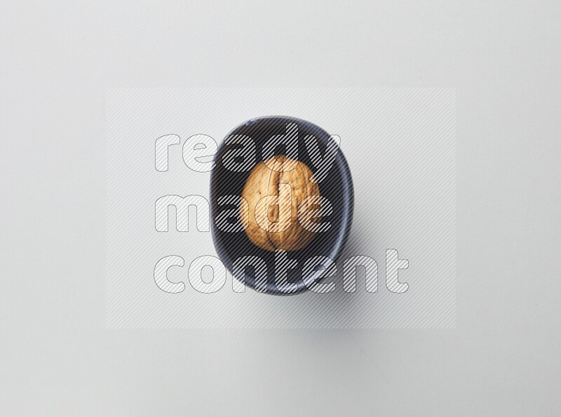 Top-view shot of walnut in a container on white background