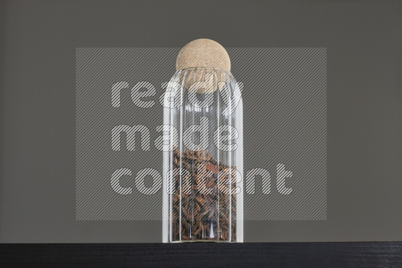 Star anise in a glass jar on black background