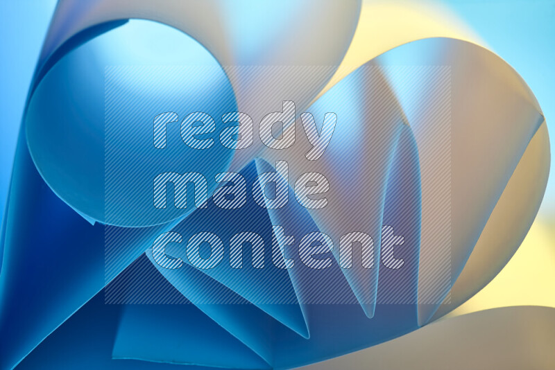 عرض فني لطيات الورق تخلق مزيج من الأشكال الهندسية، مضاءة بإضاءة ناعمة بدرجات اللون الأزرق والالوان الدافئة