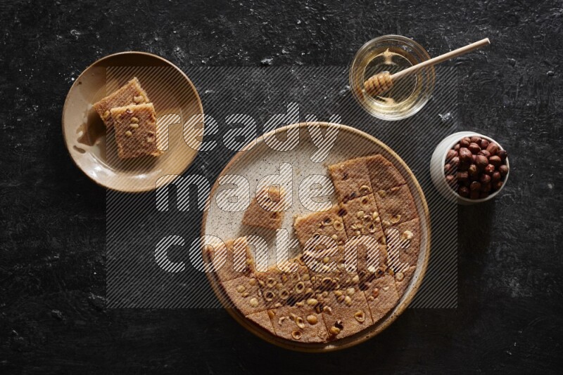 Basbousa with nuts and honey in a dark setup
