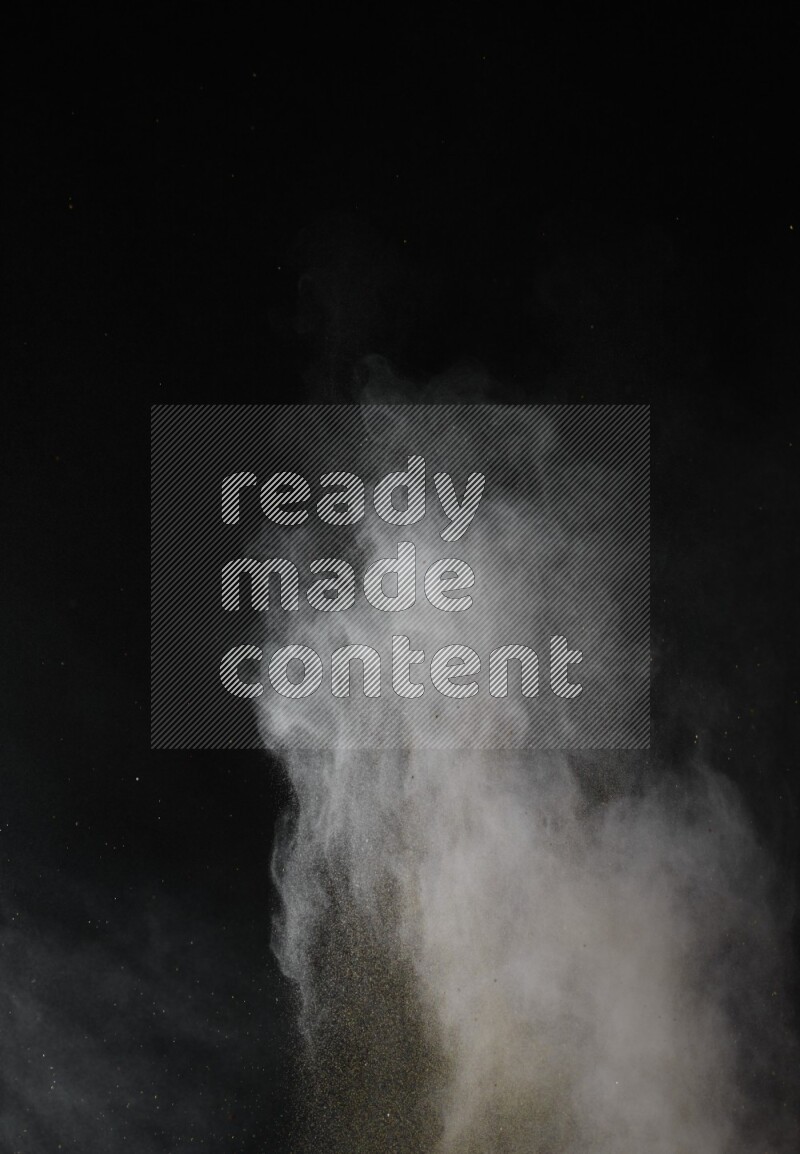 A side view of brown powder explosion on black background