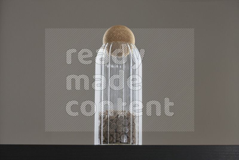 أزرار متنوعة في وعاء زجاجي علي خلفية سوداء