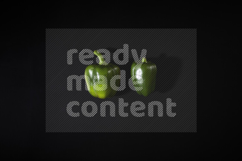 Green bell pepper on black background