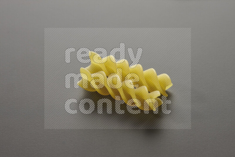 Fusilli pasta on grey background