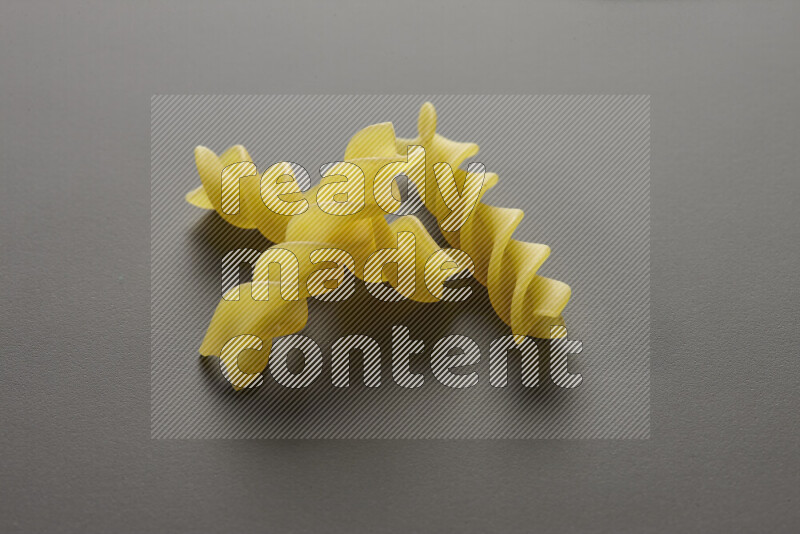 Fusilli pasta on grey background