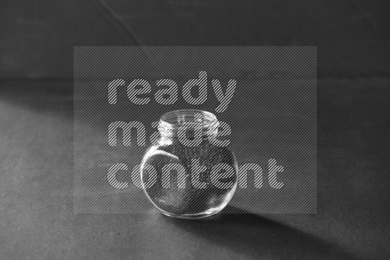 حبة البركة في وعاء زجاجي علي خلفية سوداء