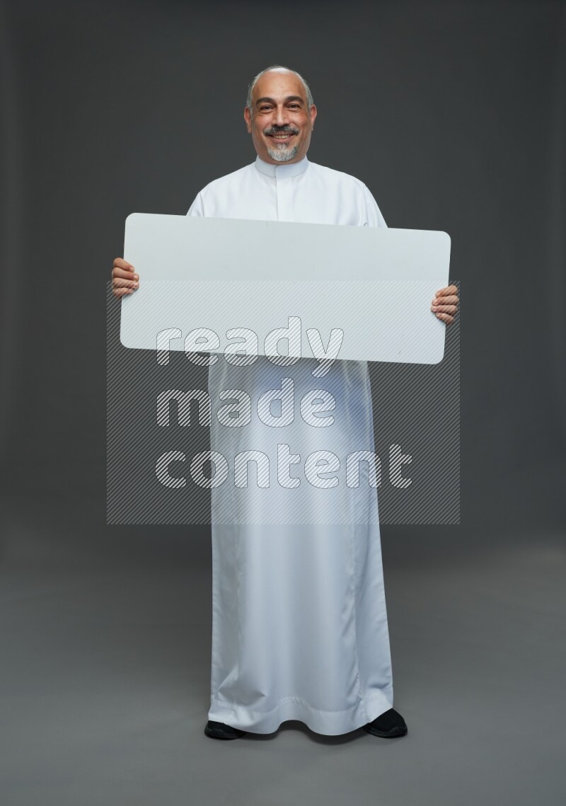 Saudi man without shomag Standing holding social media sing on gray background