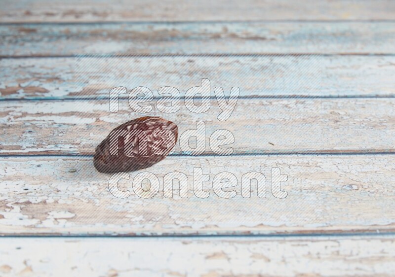 one madjoul date on a light blue wooden background