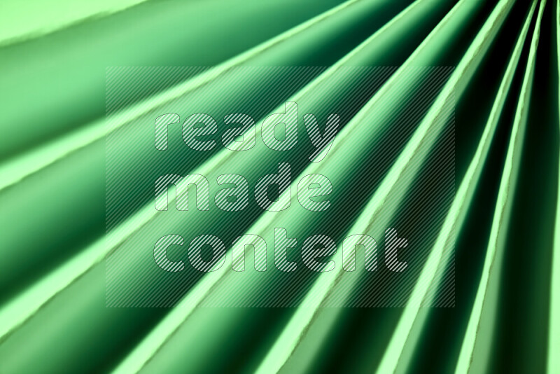 An image presenting an abstract paper pattern of lines in green tones