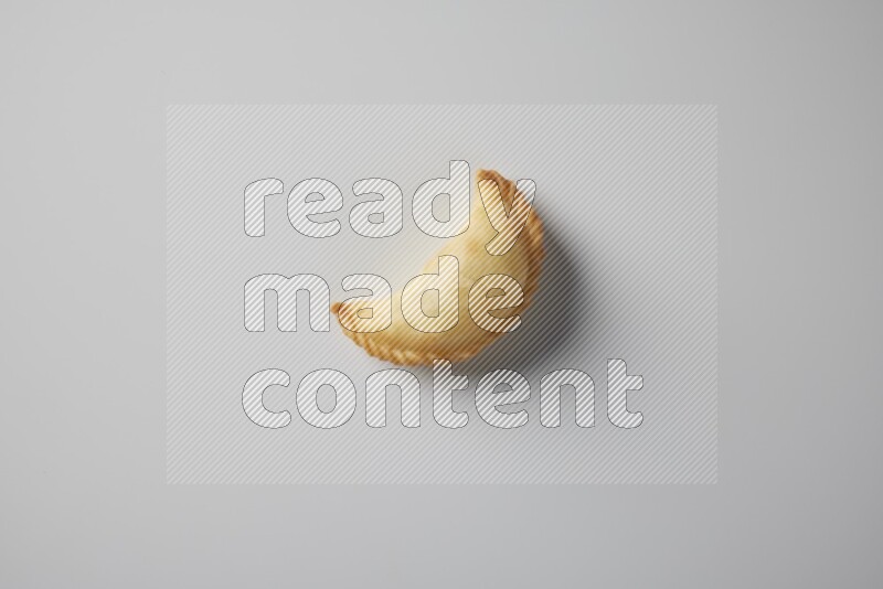 One fried sambosa from a top angle on a white background