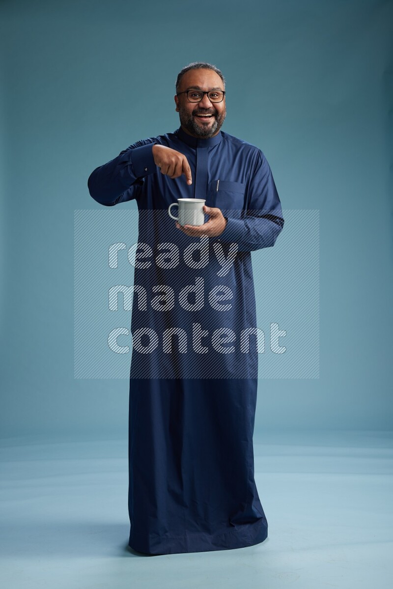 Saudi Man without shimag Standing drinking coffee on blue background