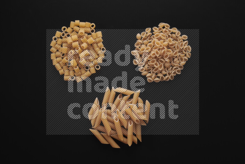 Different pasta types in bunches on black background