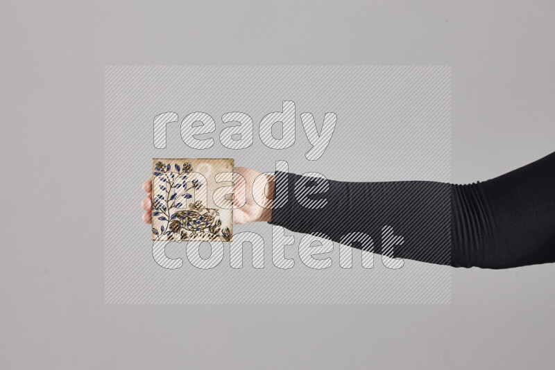 A woman in black abaya holding different pottery essentials in different positions