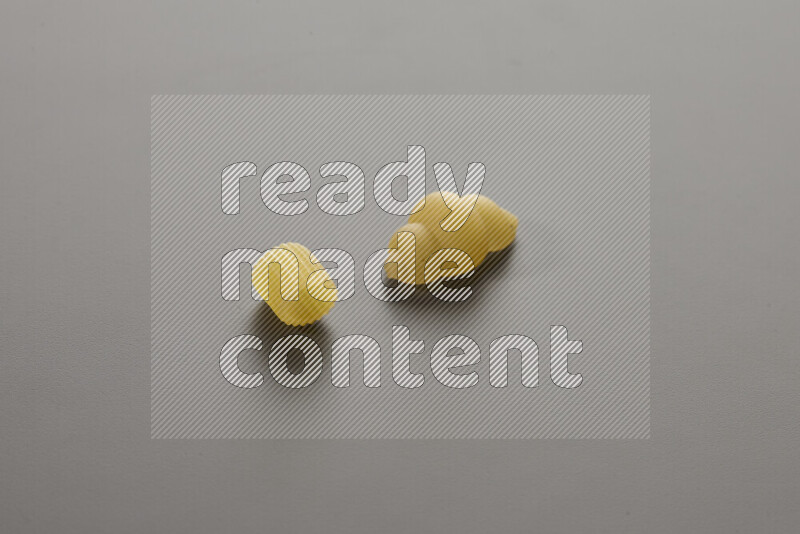 Big rings pasta with other types of pasta on grey background