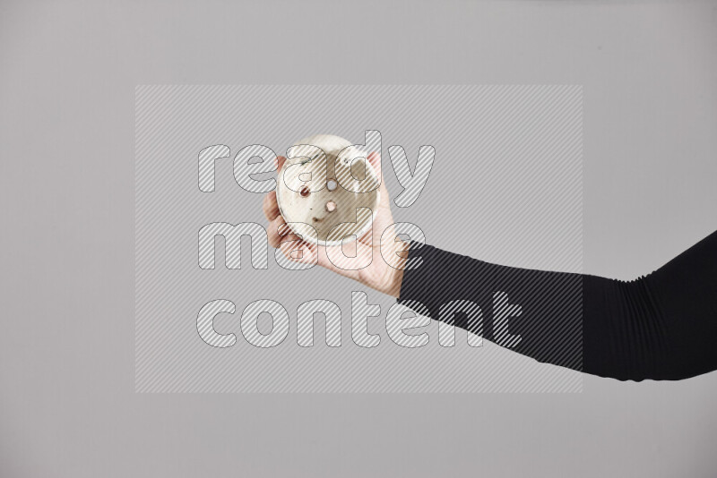 A woman in black abaya holding different pottery essentials in different positions