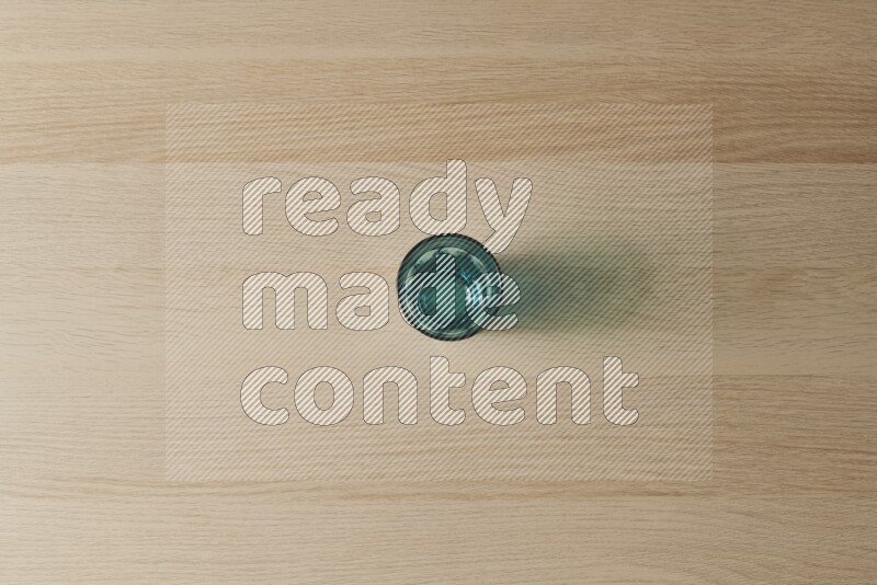 A turquoise glass cup on light wooden background