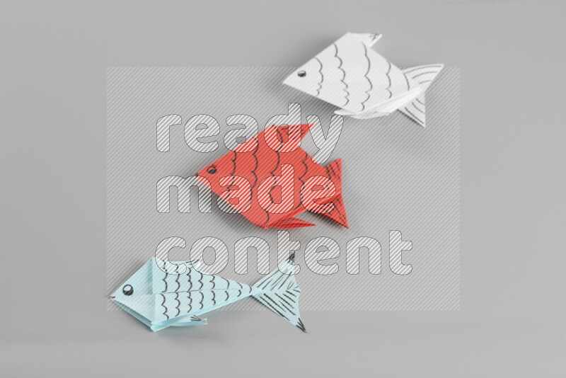 Origami fish on grey background