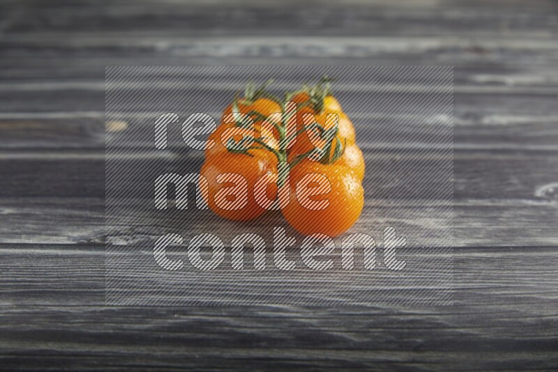 orange cherry tomato vein on a textured grey wooden background 45 degree