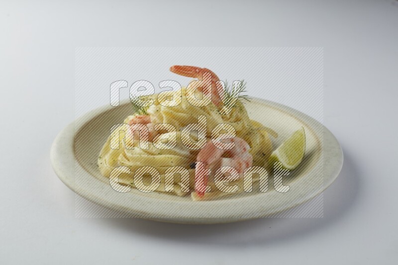 Fettuccini white sauce pasta with shrimp in a white plate on a white background