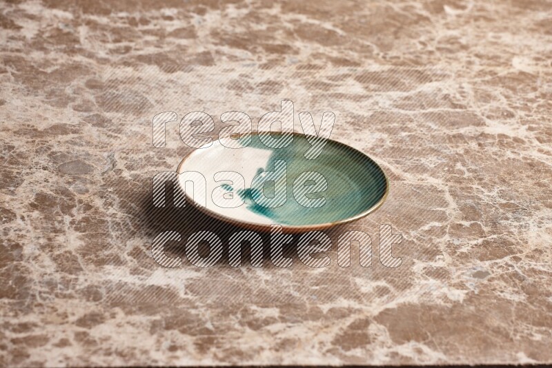A multicolored pottery plate on beige marble background