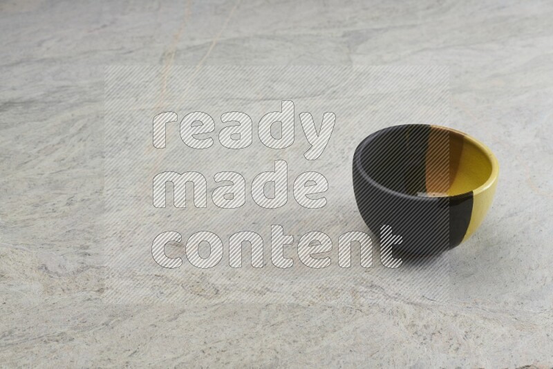 A multicolored pottery bowl on grey marble background