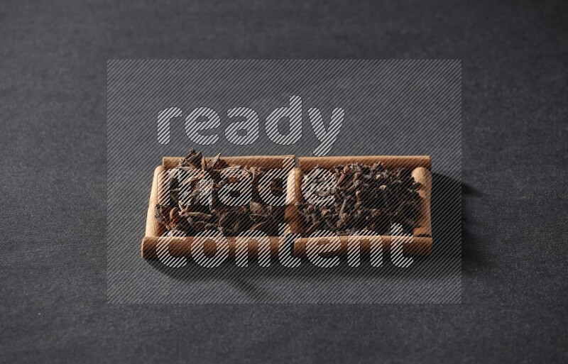 2 squares of cinnamon sticks full of star anise and cloves on black flooring