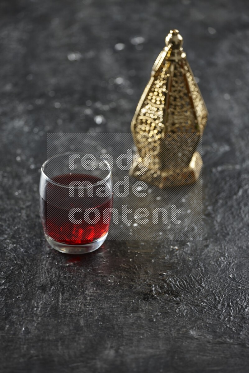 A golden lantern with different drinks, dates, nuts, prayer beads and quran on textured black background