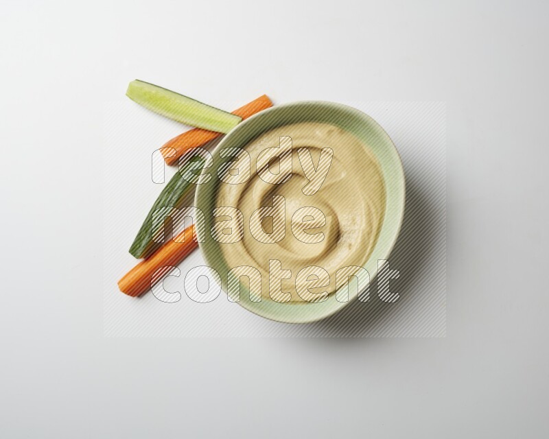 plain Hummus in a green plate on a white background