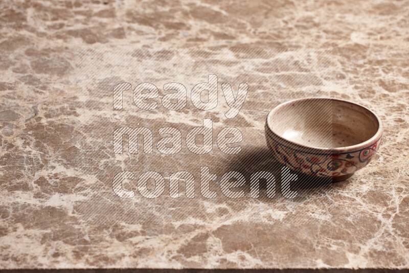 A decorative pottery bowl on beige marble background