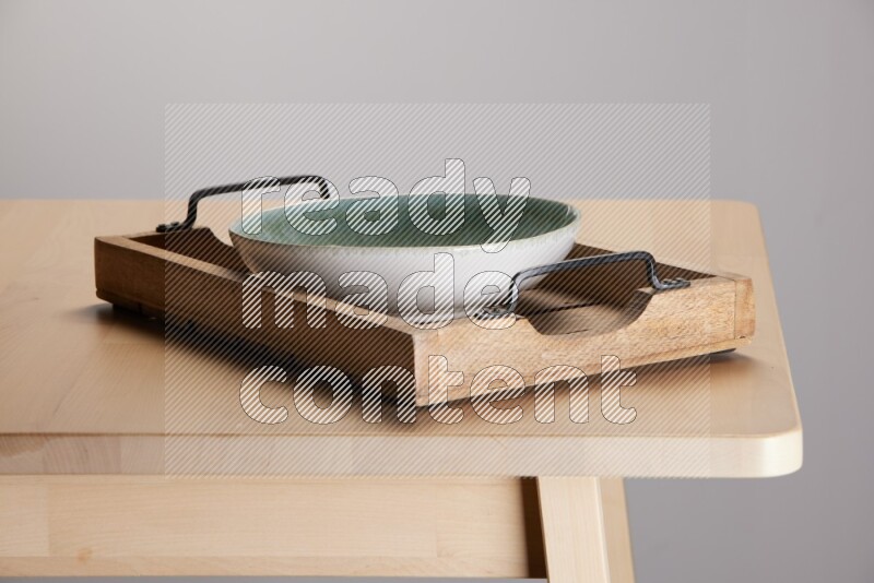 multi colored  bowl on a light colored rectangular wooden tray with handles