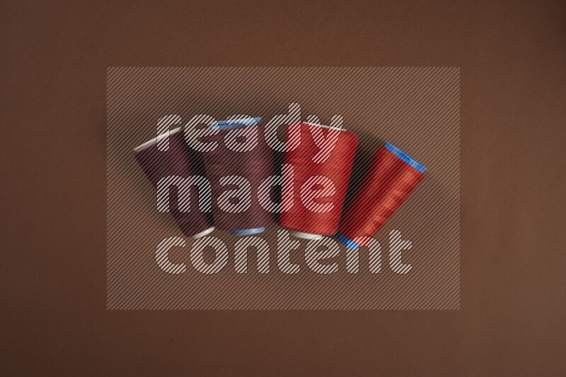 A red collection of sewing and tailoring tools arranged on a brown background