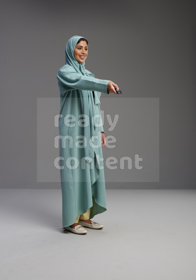 Saudi Woman wearing Abaya standing holding car key on Gray background
