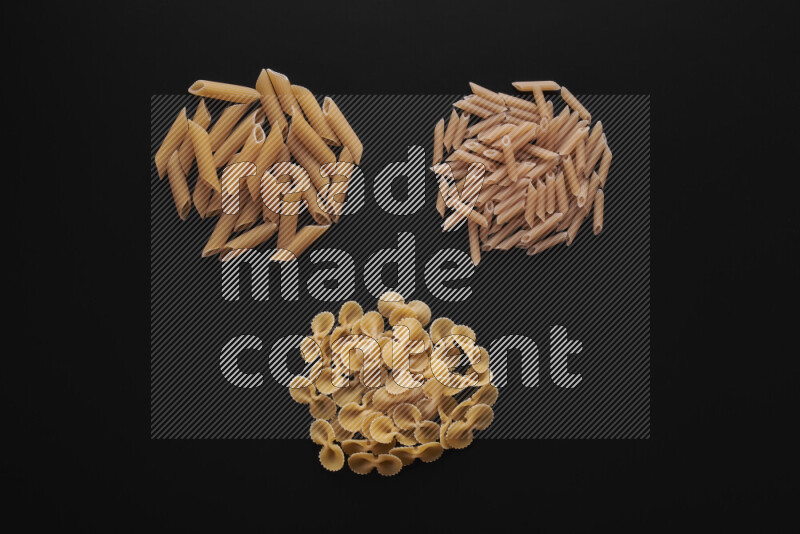 Different pasta types in bunches on black background