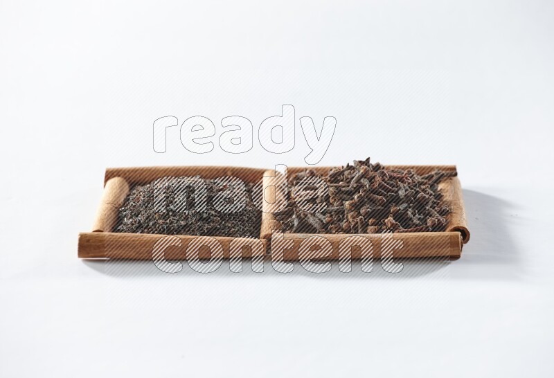 2 squares of cinnamon sticks full of black tea and cloves on white flooring