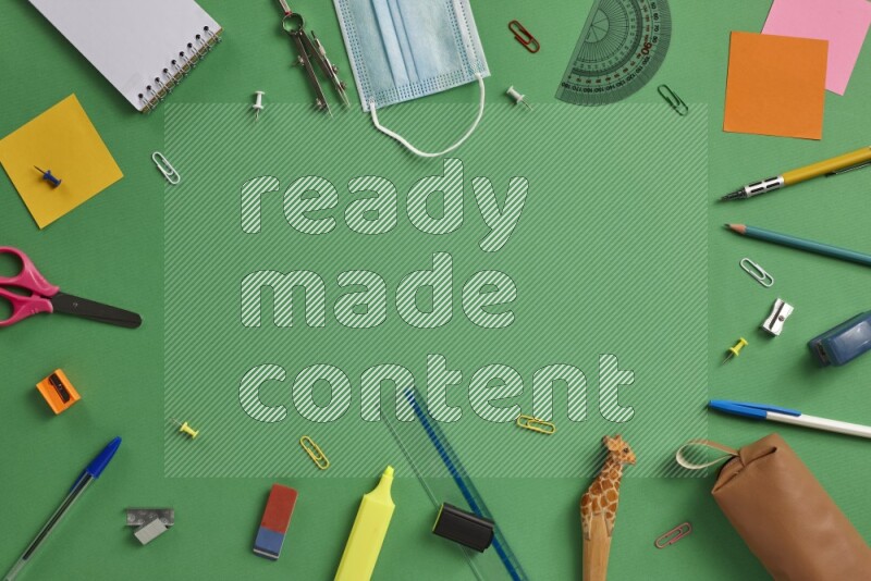 مستلزمات مدرسية مختلفة على خلفية خضراء