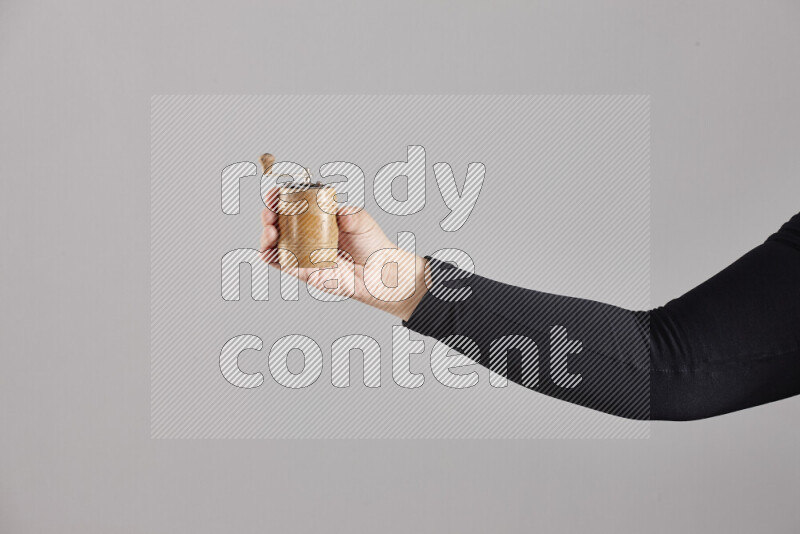 امرأة ترتدي عباءة سوداء تحمل أدوات خشبية مختلفة في أوضاع متعددة